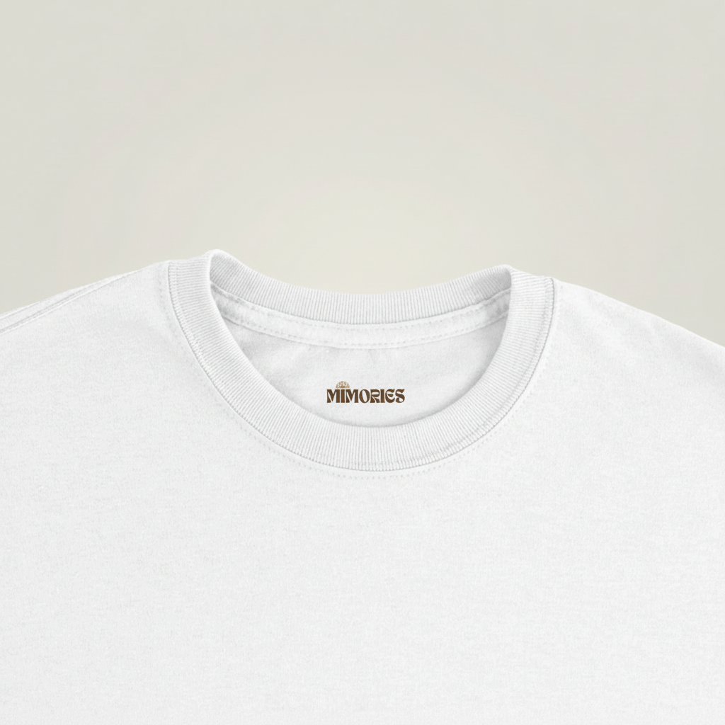 Gros plan du col et de l’étiquette du T-shirt L’ombre des Géants couleur White sur fond studio gris chaud uniforme