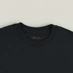 Gros plan du col et de l’étiquette du T-shirt Rivières & Falaises couleur Black sur fond studio gris chaud uniforme